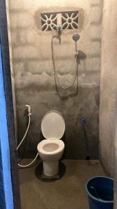 een badkamer met een toilet en een douche bij Camp Binoclutan Kubotel in Botolan