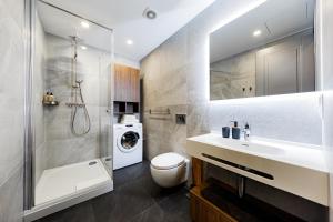 a bathroom with a sink and a washing machine at RIGAAPARTMENT ELIZABETES 22 Self-Service Aparthotel in Riga