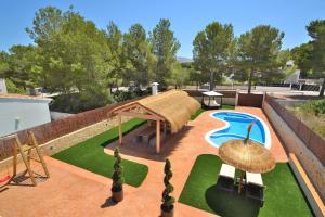 a backyard with a swimming pool and a straw roof at 066 Villa Mexic 41 ETV8816 by Mallorca Charme in Santa Margalida