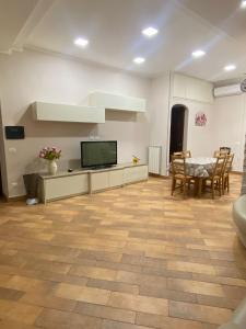 a living room with a television and a table and chairs at Domus Melius in Castellammare di Stabia
