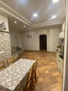 a living room with a table and chairs and a kitchen at Domus Melius in Castellammare di Stabia