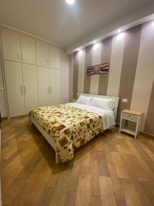 a bedroom with a large bed and a wooden floor at Domus Melius in Castellammare di Stabia