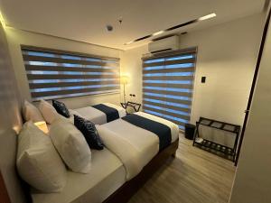 a bedroom with two beds and a large window at Coron 180 Hotel in Coron