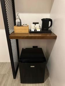 a shelf with a coffee maker and a coffee pot on it at Coron 180 Hotel in Coron