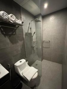 a bathroom with a toilet and a glass shower at Coron 180 Hotel in Coron