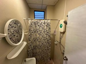 a bathroom with a shower with a toilet and a mirror at Villa’s Homestay in Chiang Mai