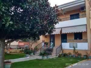 a house with stairs and a tree in the yard at Επικούρεια Κατοικία in Gorgogýrion