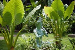 a statue in a garden with green plants at Wave-F in Ko Kood