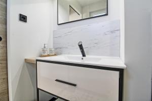 a bathroom with a white sink and a mirror at Aux 3 Glands - Nature & Spa in Dieffenbach-au-Val