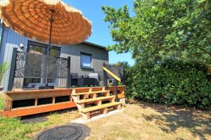 a bench with an umbrella in front of a house at Aux 3 Glands - Nature & Spa in Dieffenbach-au-Val