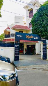 un hotel con un cartel frente a un edificio en Mauji's Villa Hotel & Guest House en Prayagraj