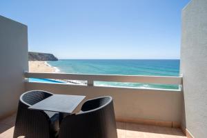 balcón con mesa, sillas y vistas al océano en Arribas Sintra Hotel en Sintra