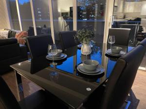 - une table à manger avec des verres et des assiettes dans l'établissement Sky View by condokeeper, à Londres