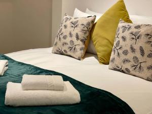 - une serviette blanche assise au-dessus d'un lit avec des oreillers dans l'établissement Sky View by condokeeper, à Londres