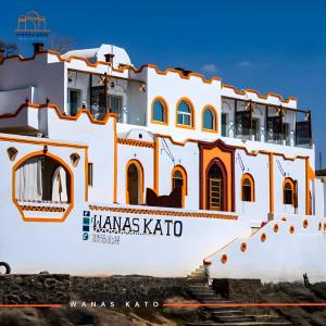 a large white building with orange trim at Wanas Kato Guest House in Shellal