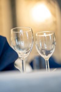 dos copas de vino vacías sentadas en una mesa en Frederiksværk Hotel, en Frederiksværk