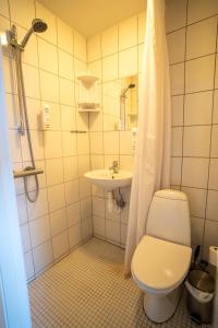 uma casa de banho com um WC, um lavatório e um chuveiro em Frederiksværk Hotel em Frederiksværk