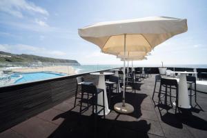 a patio with a table and chairs and the ocean at Arribas Sintra Hotel in Sintra