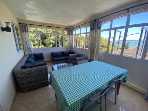 a living room with a table and chairs and a couch at Vue sur mer in La Gaulette