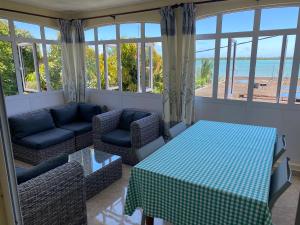 a living room with a table and a couch and windows at Vue sur mer in La Gaulette