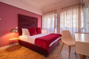 Un dormitorio con una cama grande con sábanas rojas y una mesa. en D'Ávila Peixinho 180, en Aveiro
