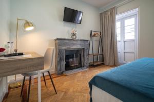 um quarto com uma cama, uma secretária e uma lareira em D'Ávila Peixinho 180 em Aveiro