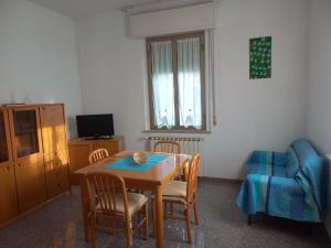 a dining room with a table and chairs and a couch at Casa di Adele con giardino privato a 150 mt dal mare in Senigallia