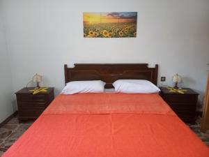 una camera da letto con un grande letto con una coperta rossa di Casa di Adele con giardino privato a 150 mt dal mare a Senigallia
