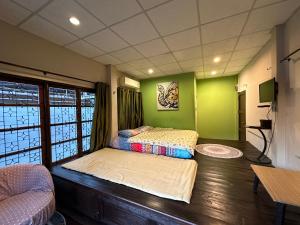 two beds in a room with green walls at Villa’s Homestay in Chiang Mai