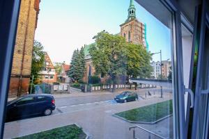 a view from a window of a street with a church at Saint Barbara Gorgeous 3 room apartments in the heart of Gdansk in Gdańsk