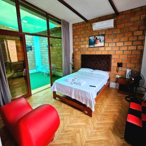 um quarto com uma cama e uma cadeira vermelha em MORALES BUNGALOWS em Tarapoto