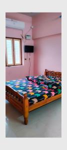 een slaapkamer met een bed met een kleurrijk dekbed bij THIRUNALLAR S A RESIDENCY in Tirunallār
