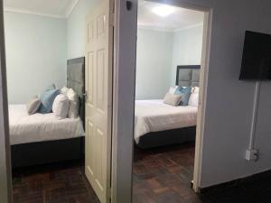 sypialnia z 2 łóżkami i lustrem w obiekcie The Royal Blue w mieście Sandown