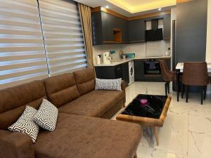a living room with a couch and a kitchen at Retro 15 3+1 in Alanya