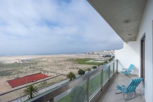 a balcony with two chairs and a view of the beach at Bella Vista Figueira - 1ère ligne Océan in Buarcos