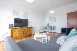 a living room with a couch and a tv at Bella Vista Figueira - 1ère ligne Océan in Buarcos