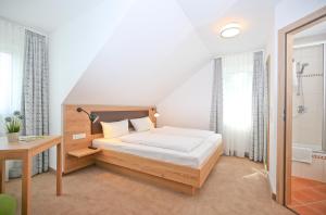 ein Schlafzimmer mit einem Bett und einem Schreibtisch in einem Zimmer in der Unterkunft Bauernhofpension Hof Dödesberg in Bad Berleburg