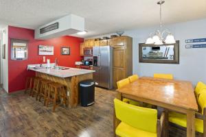 une cuisine et une salle à manger avec une table en bois et des chaises jaunes dans l'établissement Phoenix 207 condo, à Steamboat Springs