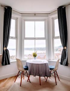 a dining room with a table and chairs in front of a window at Seascape Scarborough Stunning Seaview Holiday Home Apartment in Scarborough