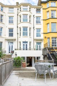 een patio met 2 stoelen en een tafel voor een gebouw bij Seascape Seaview Apartment hot tub hire subject to availability in Scarborough