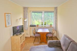 een woonkamer met een tafel en een televisie bij Bauernhofpension Hof Dödesberg in Bad Berleburg