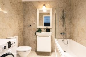 a bathroom with a sink and a toilet and a tub at Central Residence Apartment 505 in Bucharest +44 photos