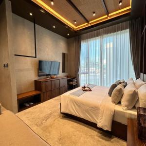 1 dormitorio con 1 cama grande y TV en TANA Beach Villas, en Lian