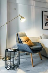 a living room with a chair and a lamp at Central Residence Apartment 505 in Bucharest