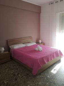 um quarto com uma cama rosa com duas toalhas em Malatesta House em Roma