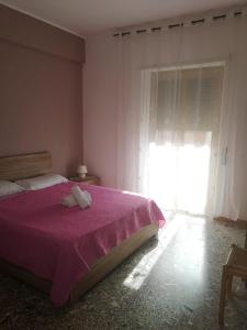 um quarto com uma cama com um cobertor roxo e uma janela em Malatesta House em Roma