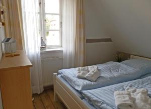 - une chambre avec un lit et des serviettes dans l'établissement Navigare, à Wyk auf Föhr