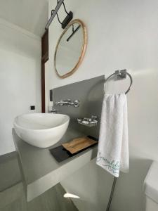 La salle de bains est pourvue d'un lavabo blanc et d'un miroir. dans l'établissement Casa Smeralda, à Dikwella