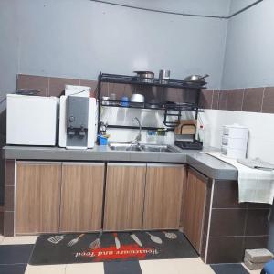 a kitchen with a sink and a counter top at Hotel Iskandar in Seri Iskandar