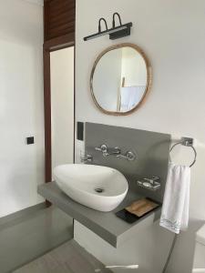 La salle de bains est pourvue d'un lavabo et d'un miroir. dans l'établissement Casa Smeralda, à Dikwella